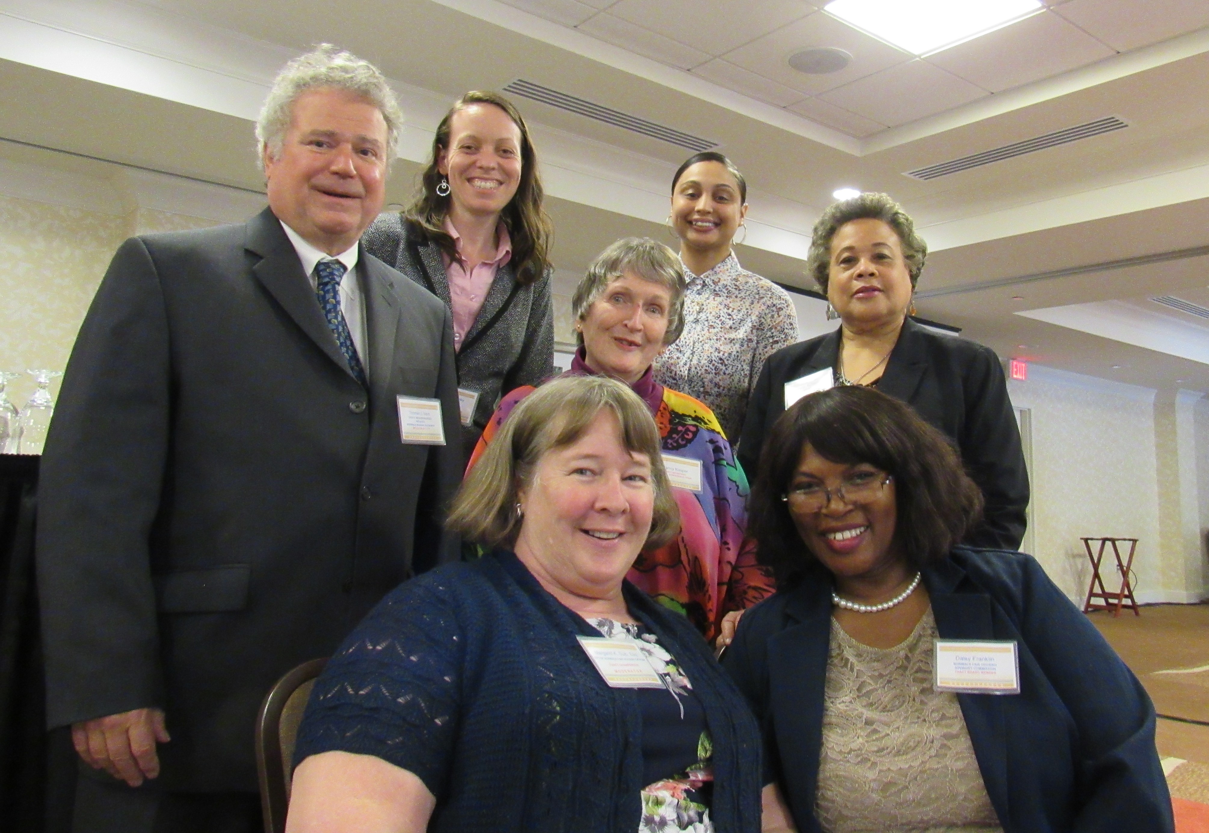 FHACT's Board of Directors are pictured at the recent conference - group of seven people, some seated and some standing, dressed professionally.
